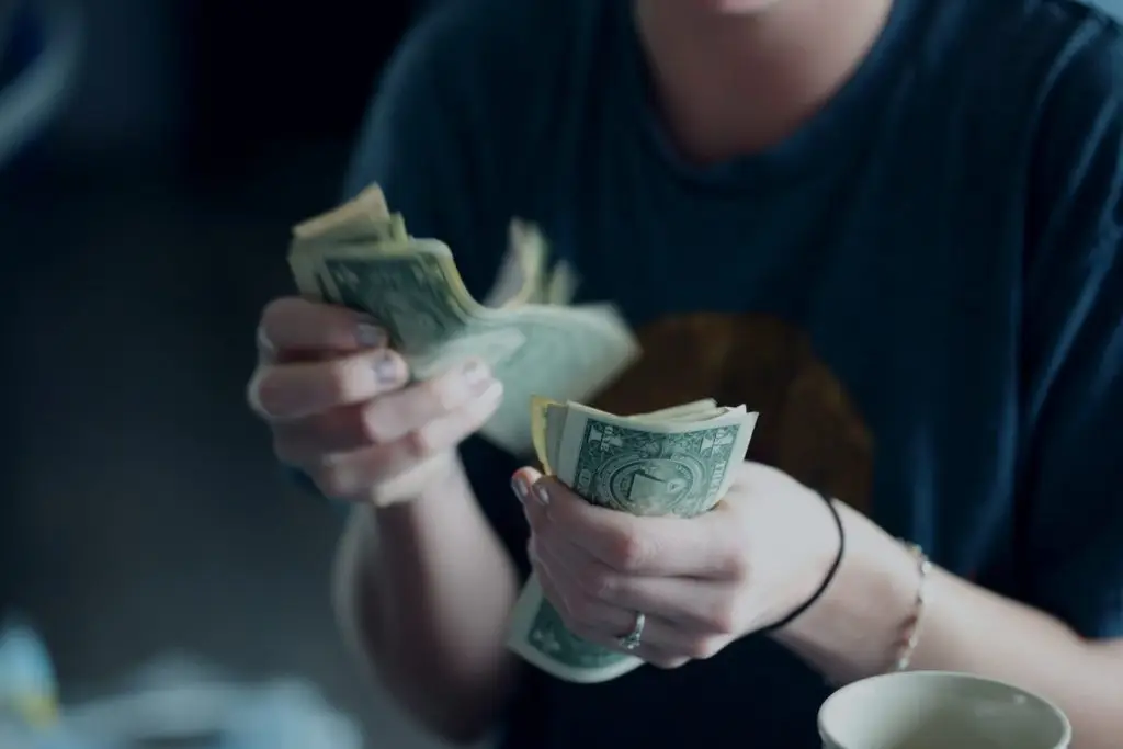 woman counting bank notes to pay her bills 