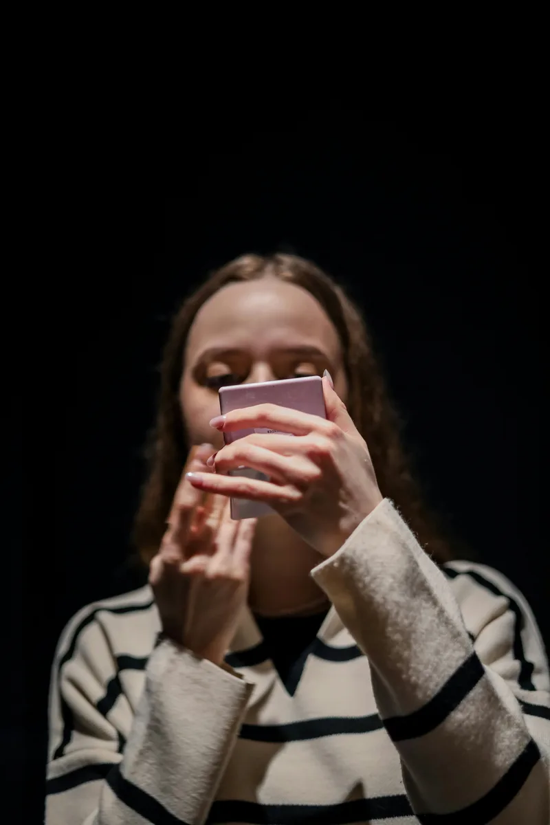 Woman looking at phone discovering someone is using her photos online