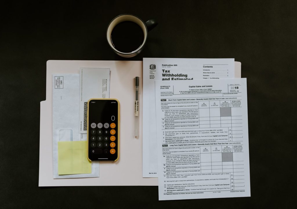 papers on desk with phone calculator and pen for determining finance for home loans