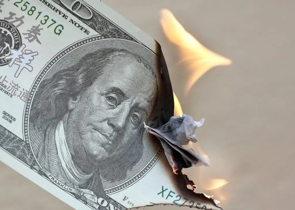 burning dollars as a show of debt and wasting money